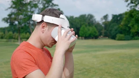 A man takes off his VR headset from his head in the park Stock Footage 112805647