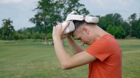 A man takes off his VR headset from his head in the park. Stock Footage 112806166