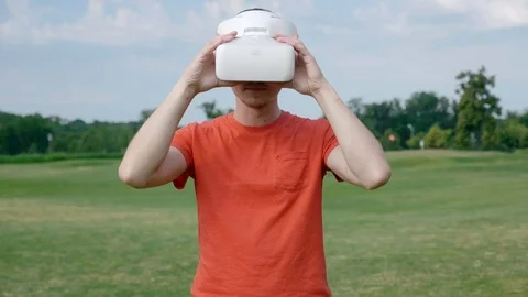 A man takes off his VR headset from his head in the park Stock Footage 113261432