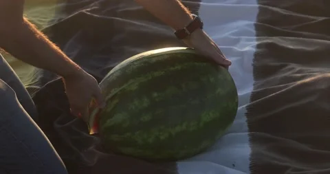 Man takes a large piece out of a watermelon Stock Footage 205436101