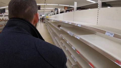 Man takes last loaf from empty supermarket shelves in lockdown, UK, 19/03/20 Stock Footage 126877815