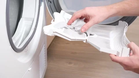 A man takes a lint filter out of dryer and cleans it from dust, lint, hair, wool Stock Footage 187813166