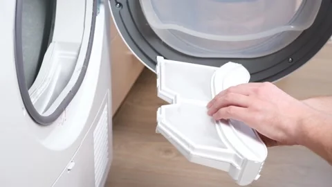 A man takes a lint filter out of dryer and cleans it from dust, lint, hair, wool Stock Footage 190651709