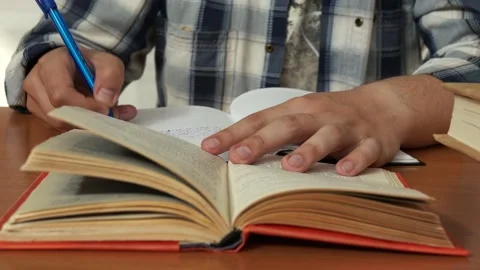 A man takes notes from a book in a notebook Stock Footage 156504247