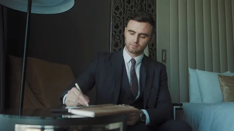 A man takes notes in a diary Видео 122934117