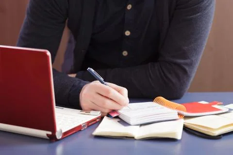 Man takes notes in a notebook. Work at home 스톡 사진