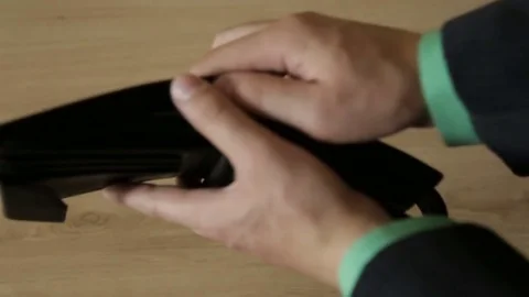 A man takes out banknotes from a leather purse Vidéo 77264984
