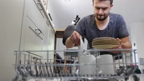 The man takes out clean dishes from the dishwasher after washing. Stock Footage 160888540