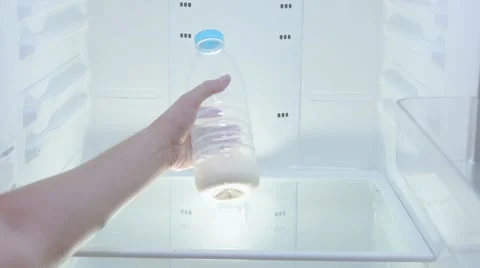 The man takes out of an empty refrigerator a bottle of milk on the bottom Stock Footage