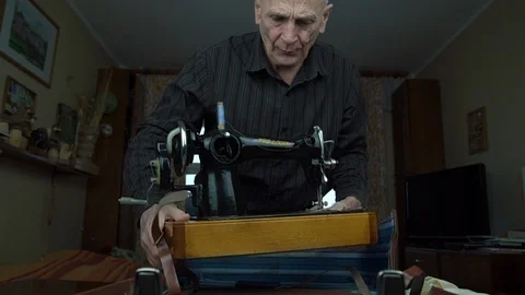 Man takes out sewing machine from suitcase and puts on table Video stock 129149785