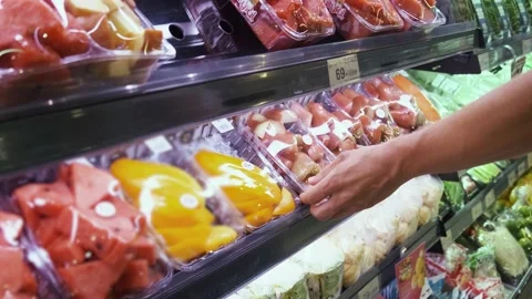 Man takes package of chopped fruit in grocery supermarket from fridge shelf Stock Footage 278999719
