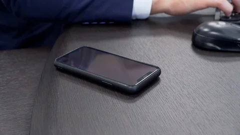 A man takes a phone at work (closeup) Stockbeeldmateriaal 130034600