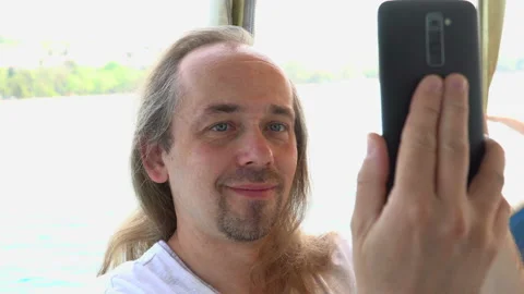 A man takes a picture of himself while cruising on a sea on a summer day. Stock Footage 106634592