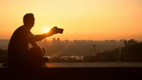 Man takes a picture while sitting on the fence Stock Footage 95205790