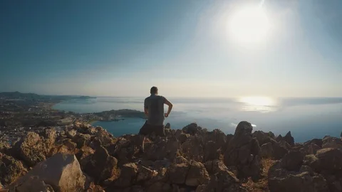 Man takes picture while standing near the edge of a cliff Stock Footage 99964540