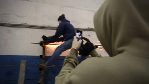 Man takes pictures as a guy does repairs Stock Footage 77203293