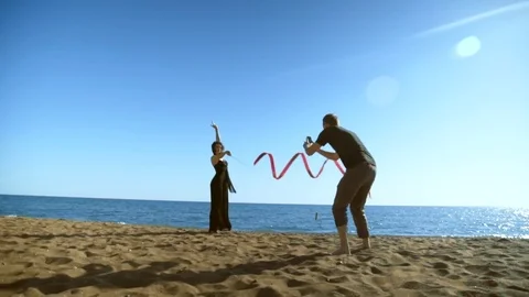 The man takes pictures on the phone. Woman in a black long dress with a red Stock Footage