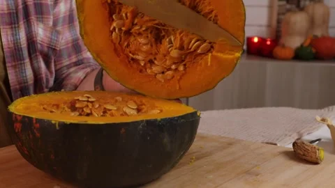  a man takes the pulp out of a pumpkin and puts it in a glass bowl to make pumpk Stock Footage 286097417