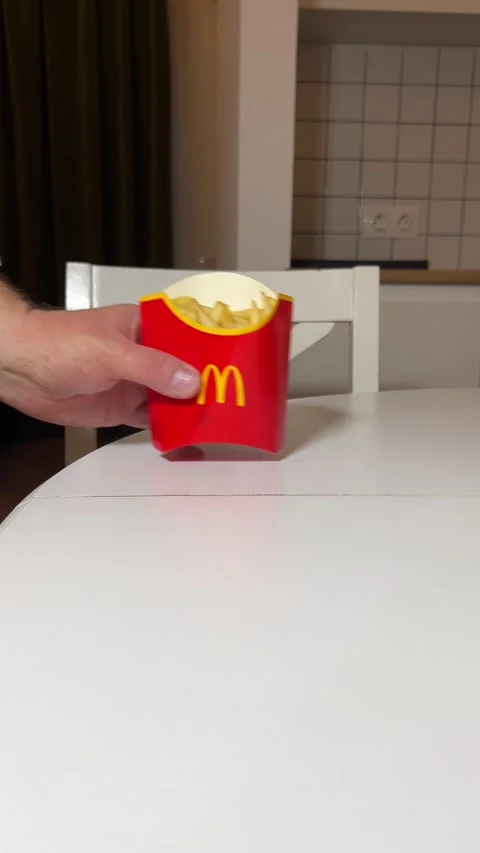 Man takes red paper bag with McDonald's logo with fresh French fries from table Stock Footage 301522728