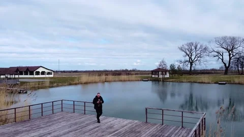 A man takes a selfie from a drone while flying over a small lake Video stock 184091242