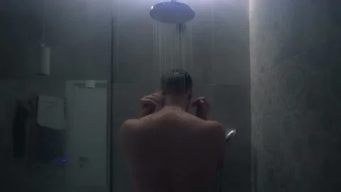 Man takes a shower in dimmed light Stock Footage 218437886