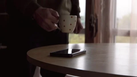 A man takes a smartphone from the table 4K Stock Footage 325988434