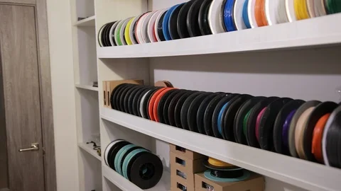 Man takes a spool with a plastic thread cable for color printing 3D printer Stock Footage 124381128