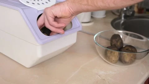 Man takes spud from vegetable container. box storing potato, onion, carrot. Stock Footage 229928161