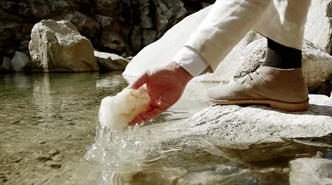 Man takes stone out of water. recreational pursuit activity Vidéo 42948876