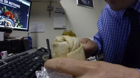 Man takes two bites of Chipotle burrito with salsa on it Stock Footage 49346956