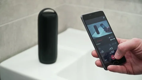 A man takes a video bluetooth speaker on the phone Stock Footage 103234171