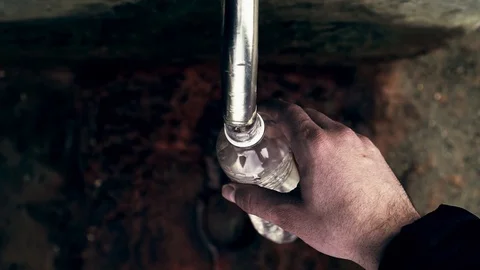 Man takes water from a natural source. narzan Stock Footage 103428567