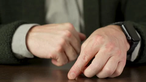 A man takes off wedding ring, putting it on table Stock Footage 264762717