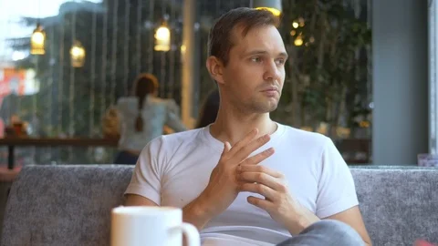 Man takes off a wedding ring while sitting in a cafe. surrounded by girls Stock Footage 125920820