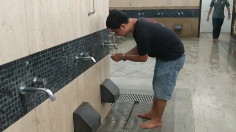 Man taking ablution water Stock Footage 256883450