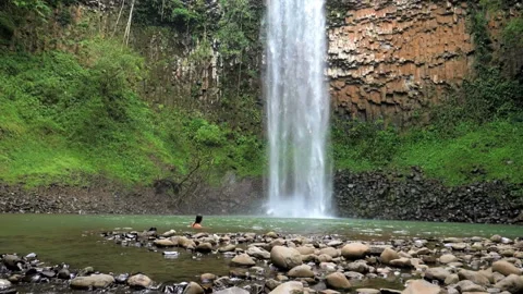Man taking a bath next to a waterfall slow motion Stock Footage 96060828