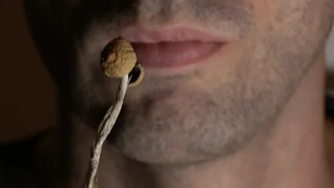 A man taking a bite from some psychedelic mushrooms, extreme close up 스톡 동영상 116157757