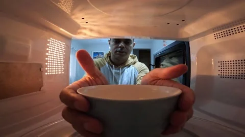 Man taking a bowl out of the microwave. Microwave concept. Bowl concept. Stock Footage 308012945