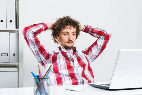 Man taking a break Young relaxed man in checked shirt in his office with h... Stock Photos