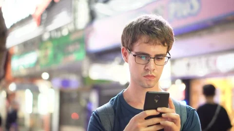 Man Taking Call, Talking and then Hanging Up in Busy City Scene at Night Stock Footage 93439030