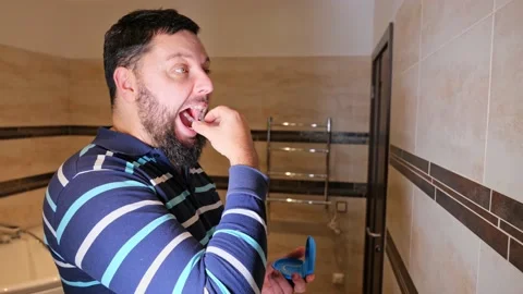 Man taking care of teeth, wearing clear orthodontic silicone transparent teeth a Stock Footage 168876155