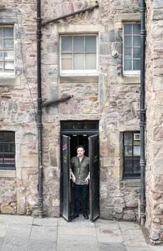 Man taking a cigarette break outside the Fire Exit doors, Edinburgh, Scotland Stock Photos