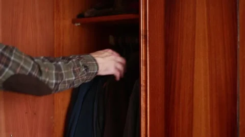 Man taking clothes from a wardrobe Stock Footage 63456318