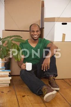 A man taking a coffee break while moving house Stock Photos