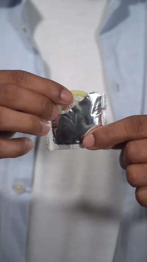 Man taking condom out of wrapper Stock Footage 314384586