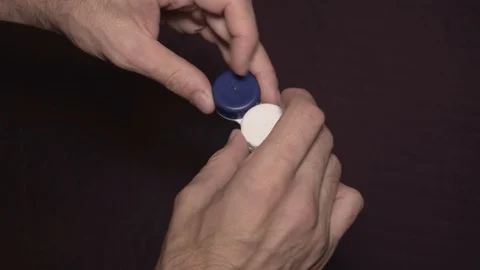 Man taking contact lens from storage case, visual impairment. Close-up of hands. Stock Footage 100107161