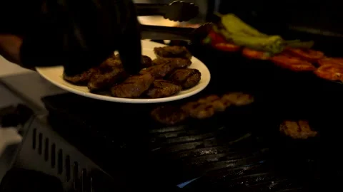 The man is taking the cooked meatballs off and placing them onto a plate Vidéo 279146406