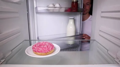 Man taking a donut out of the fridge Video stock 135381349