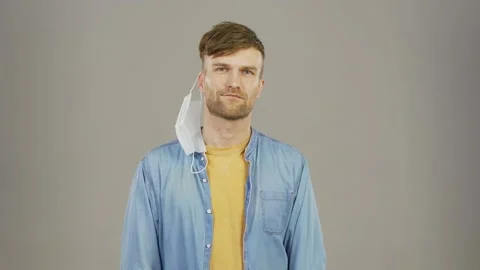 Man taking off face mask and smirking sarcastically Stock Footage 139835860