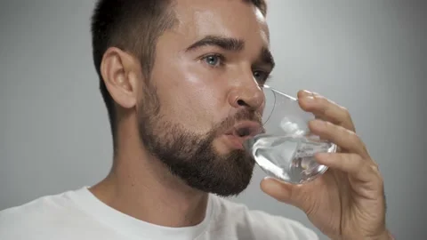 Man taking fish oil capsule with water in front of camera. Video stock 233522053